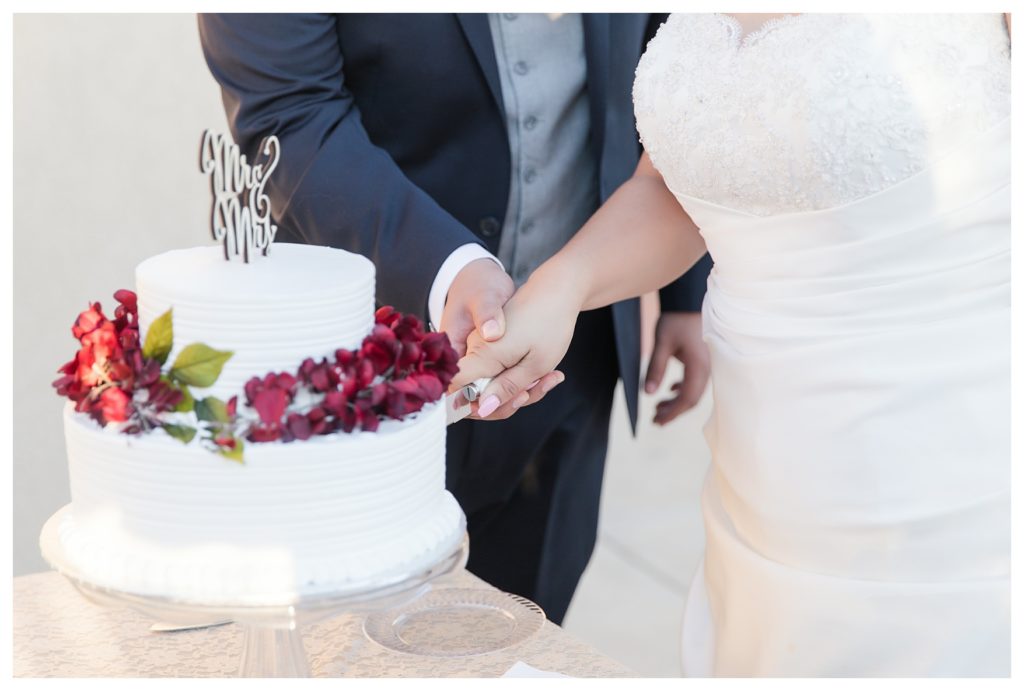 a bride and groom cut their wedding cake at their wedding at KLEA Banquet Hall