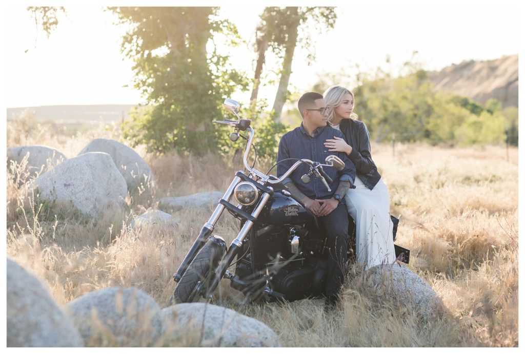 a couple sitting on their Harley Davidson during their engagement photos