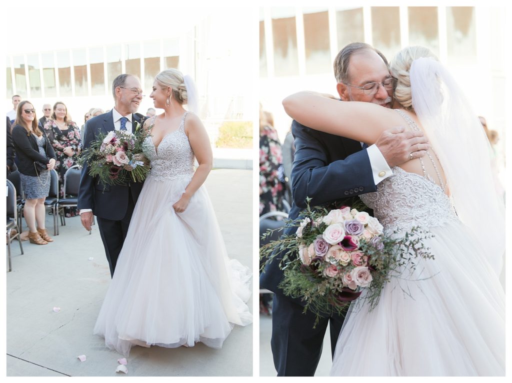 a bride hugs her father after entering her wedding at the Automobile Driving Museum in Segundo, California