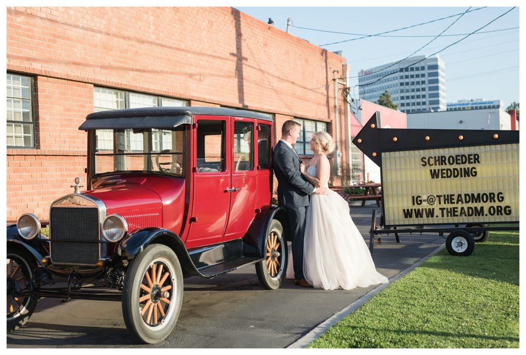 a bride and groom with a vintage car after their wedding at the Automobile Driving Museum in Segundo, California