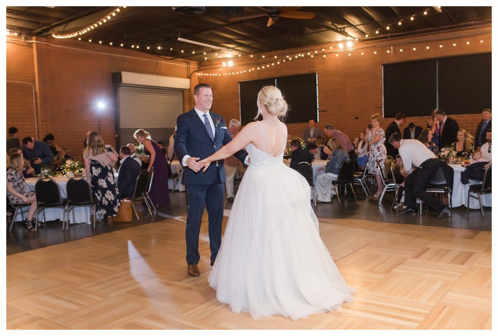 the bride and groom share a first dance at their wedding at the Automobile Driving Museum in Segundo, California