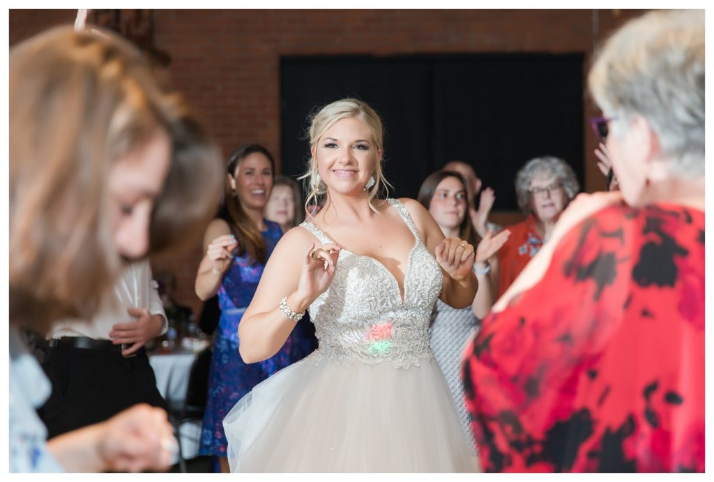 a smiling bride on the dance floor at her wedding at the Automobile Driving Museum in Segundo, California