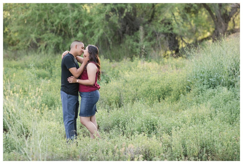 couple exploring in the field during their engagement photos at Hart Park