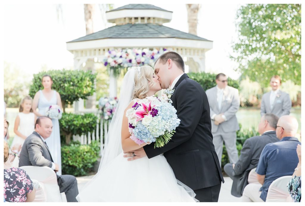 Disney themed wedding - bride and groom kissing after walking up the aisle