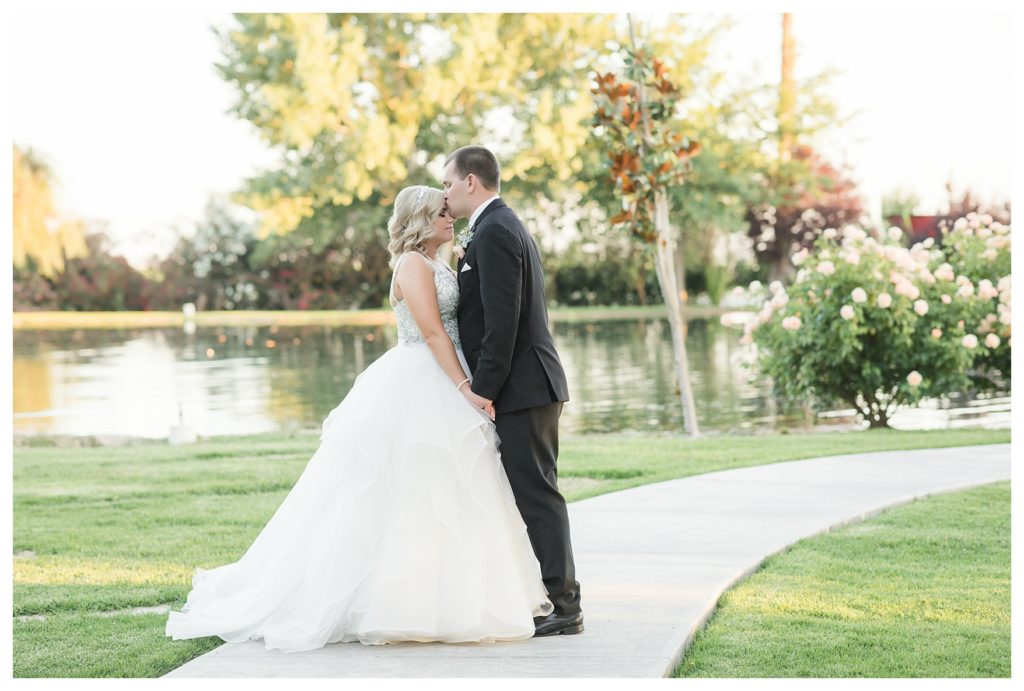 Park Place Events Wedding - bride and groom kissing in front of the pond