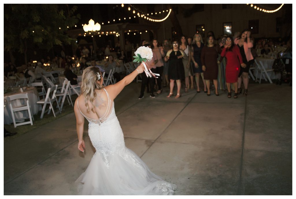 bride throws her bouquet at her wedding at The Gardens at Mill Creek reception