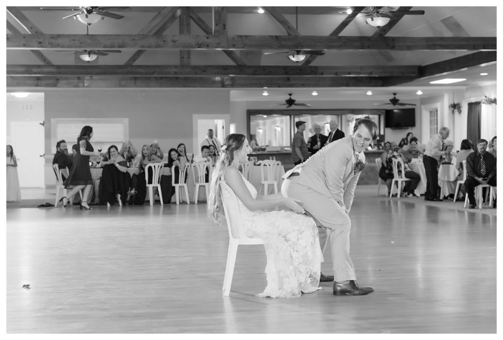funny groom dances on bride at their wedding at Kern County Basque Club