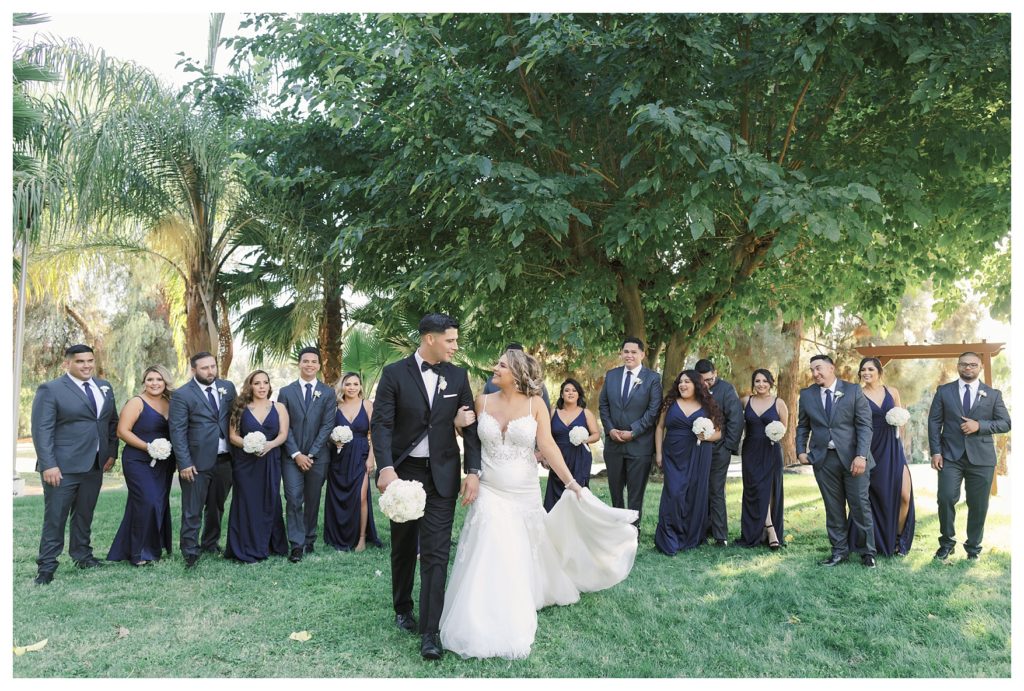 a bride and groom walk with their wedding party at a Rio Bravo Country Club wedding