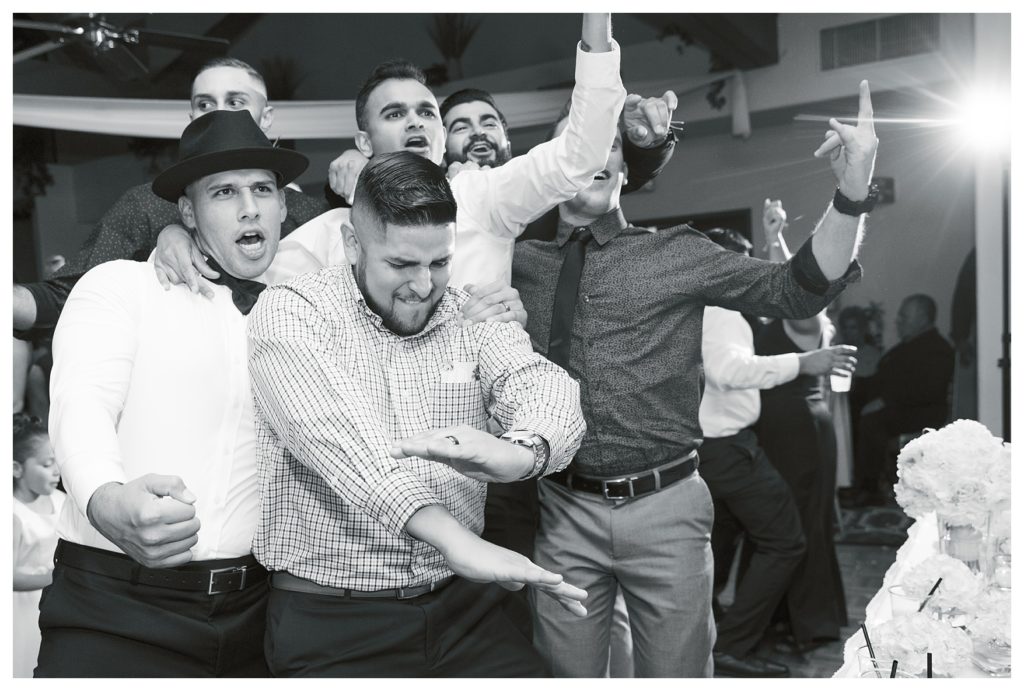men fight over a garter during the garter toss at a Rio Bravo Country Club wedding reception