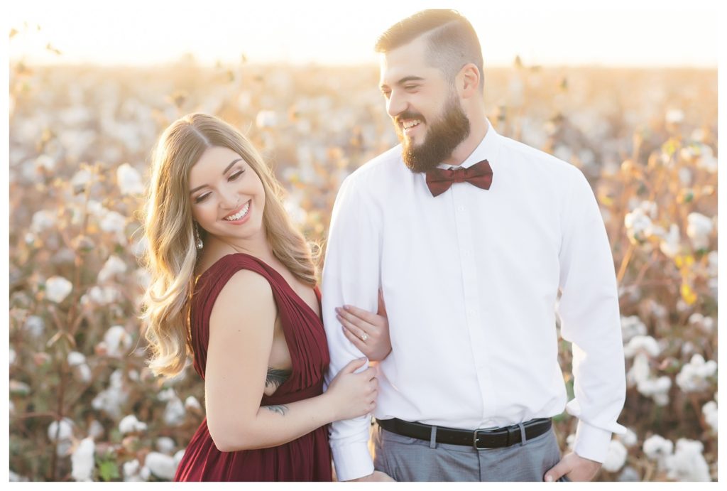 a couple laughing during their cotton field engagement photos