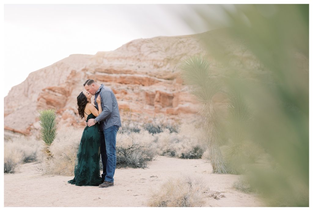 a couple kissing during their desert engagement photos
