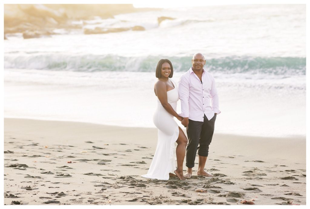 a couple poses on the beach for their engagement photos at Montaña de Oro State Park