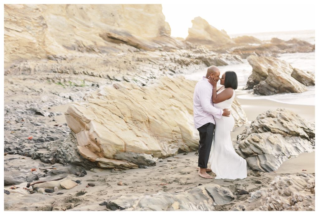 a couple kisses on the beach during engagement photos at Montaña de Oro State Park