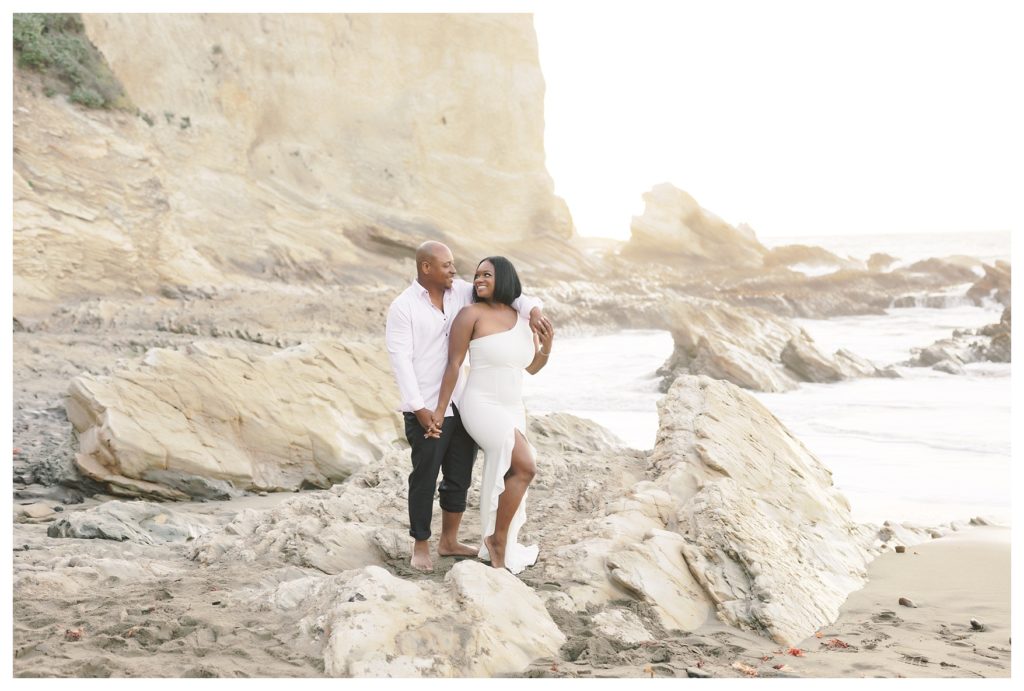 a beautiful couple poses in a beautiful landscape during engagement photos at Montaña de Oro State Park