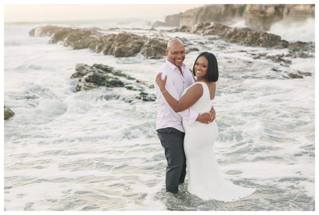 a couple plays in the water during their engagement photos at Montaña de Oro State Park