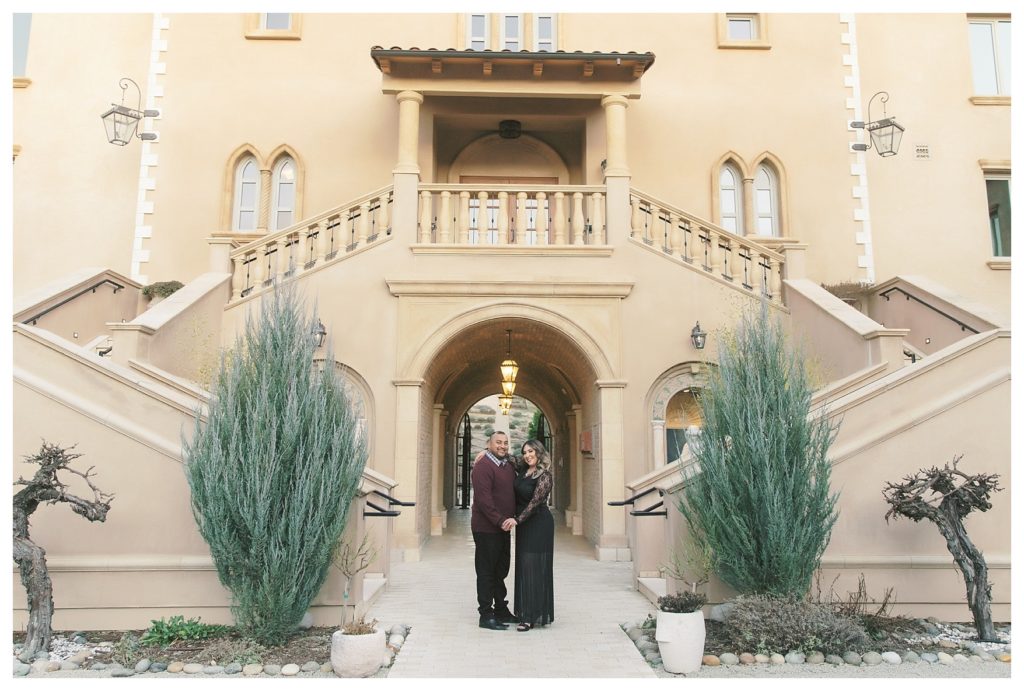 a photo of the couple in front of architecture during engagement photos at Allegretto Vineyard Resort