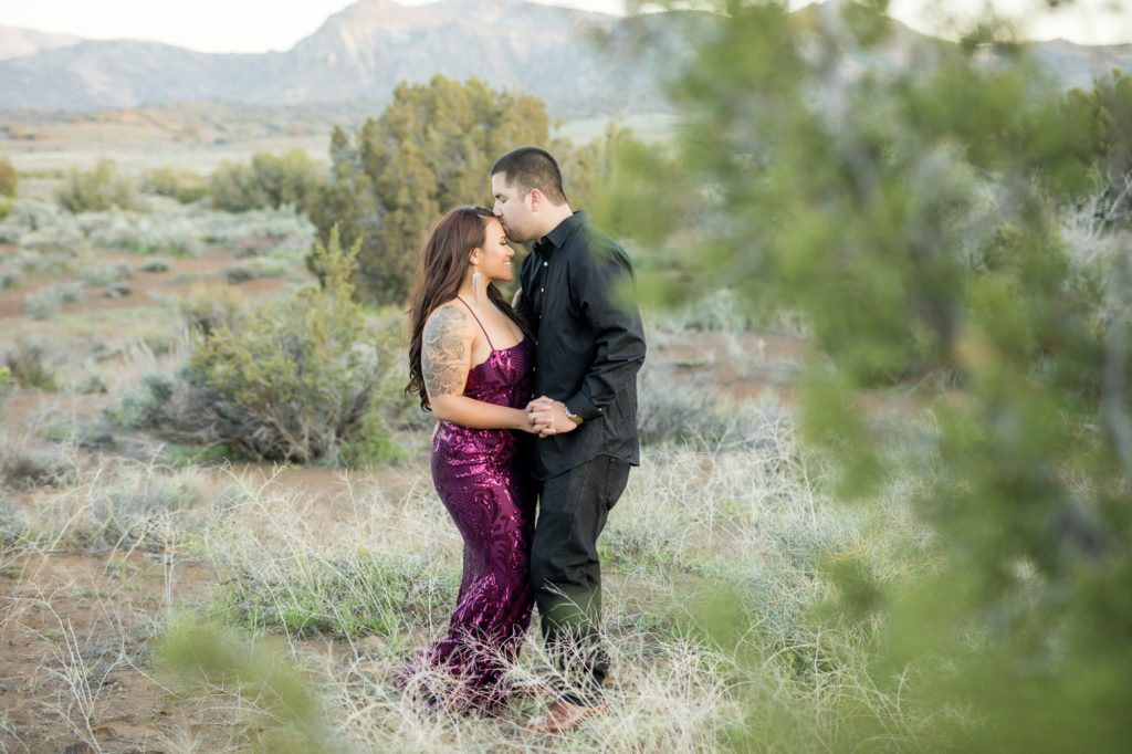 a man kisses a woman's forehead during engagement photos at Sand Canyon Ranch