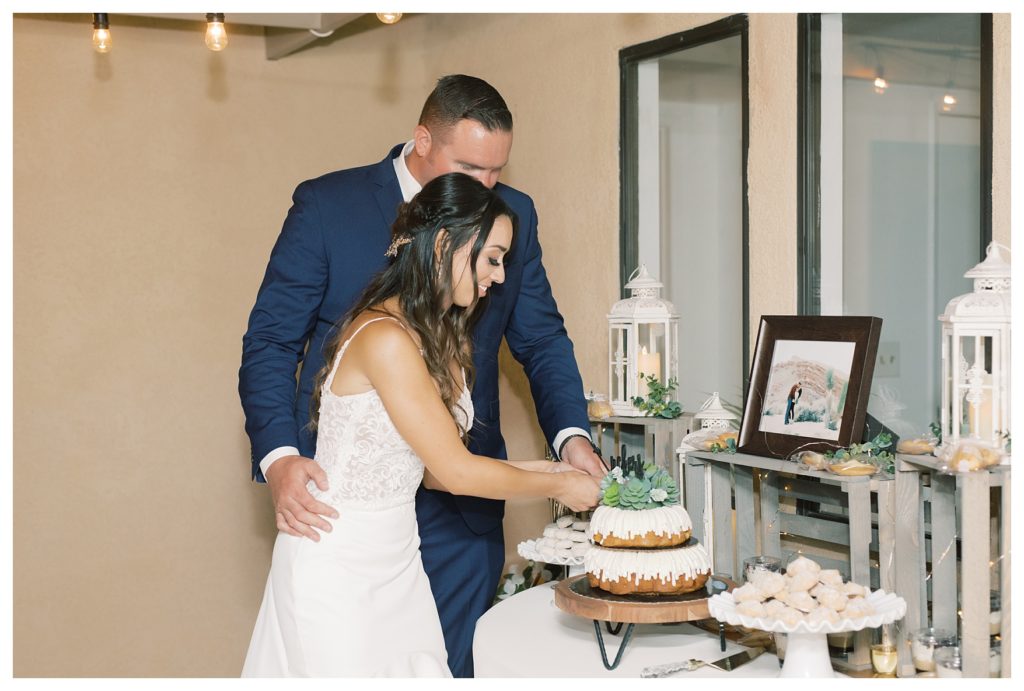a bride and groom cut their cake at their rescheduled COVID wedding
