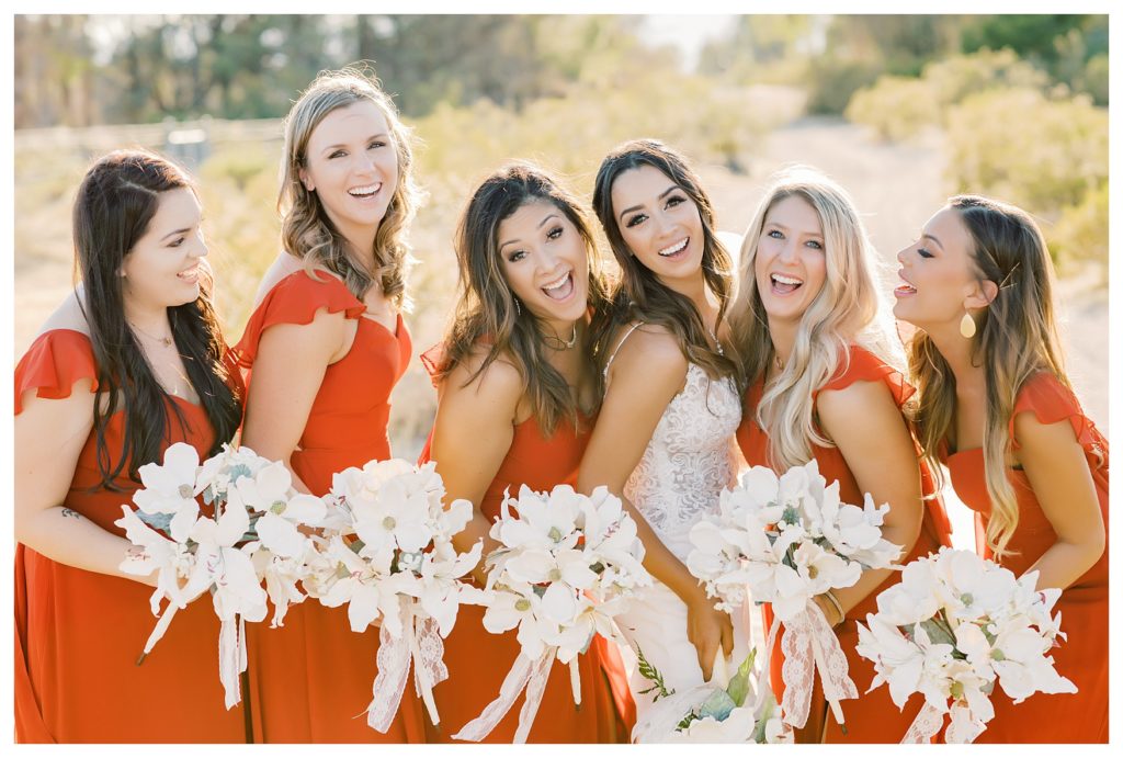 a bride laughs with her bridesmaids during her rescheduled COVID wedding