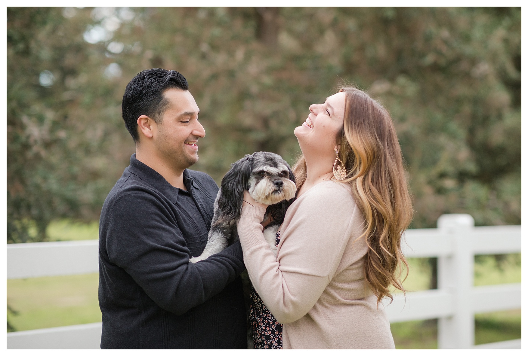 a couple plays with their dog during their fall engagement session in Bakersfield