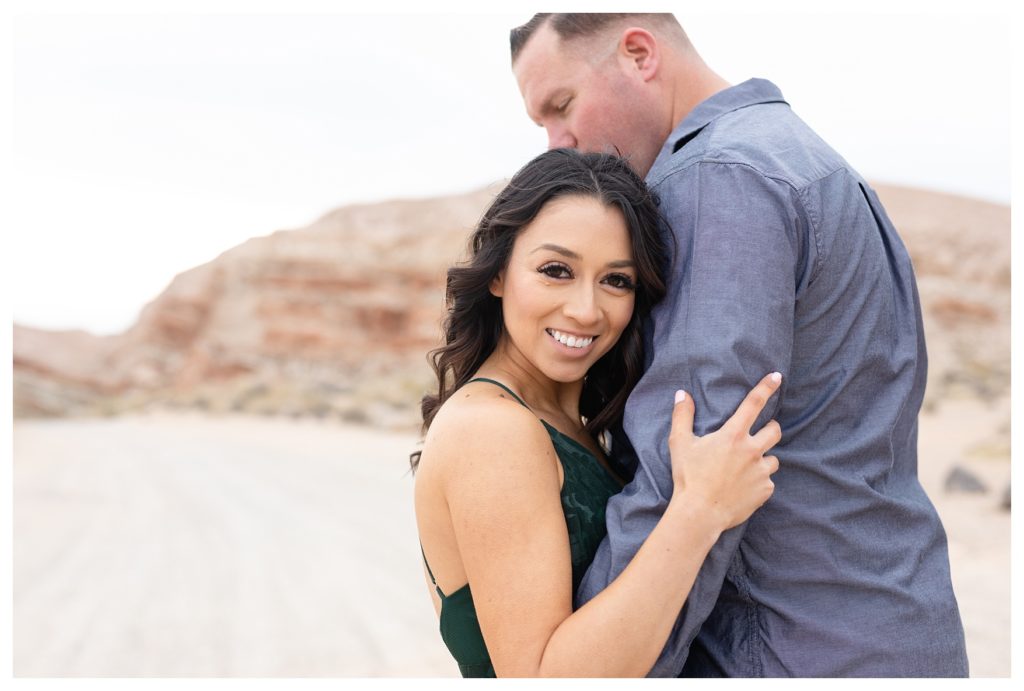 a couple cuddles during their desert engagement photos